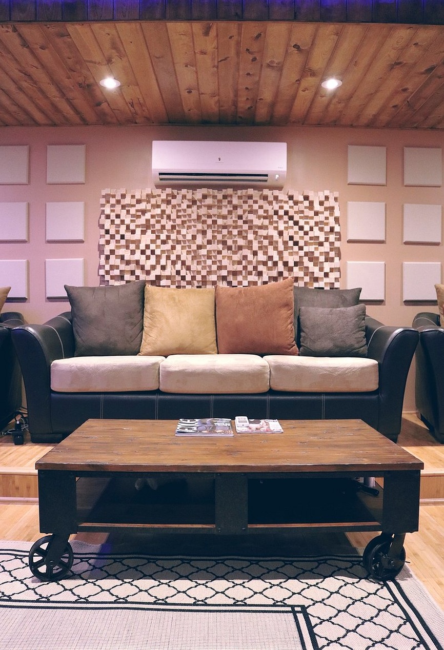 Ein modern gestalteter Wohnraum mit eleganten Holz-Akustikplatten an der Wand, die eine warme und ruhige Atmosphäre schaffen.
