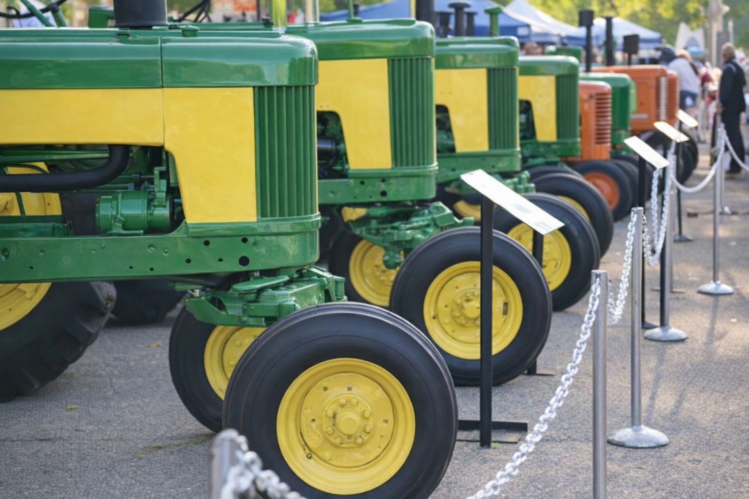 Reihe restaurierter grün-gelber Oldtimer-Traktoren bei einer Landtechnik-Auktion.